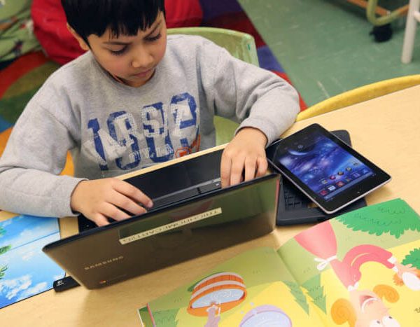 39276735-student-working-on-both-his-laptop-and-his-tablet-in-class-700px